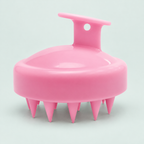 Palm scalp brush — one pink brush in a coastal studio setting.