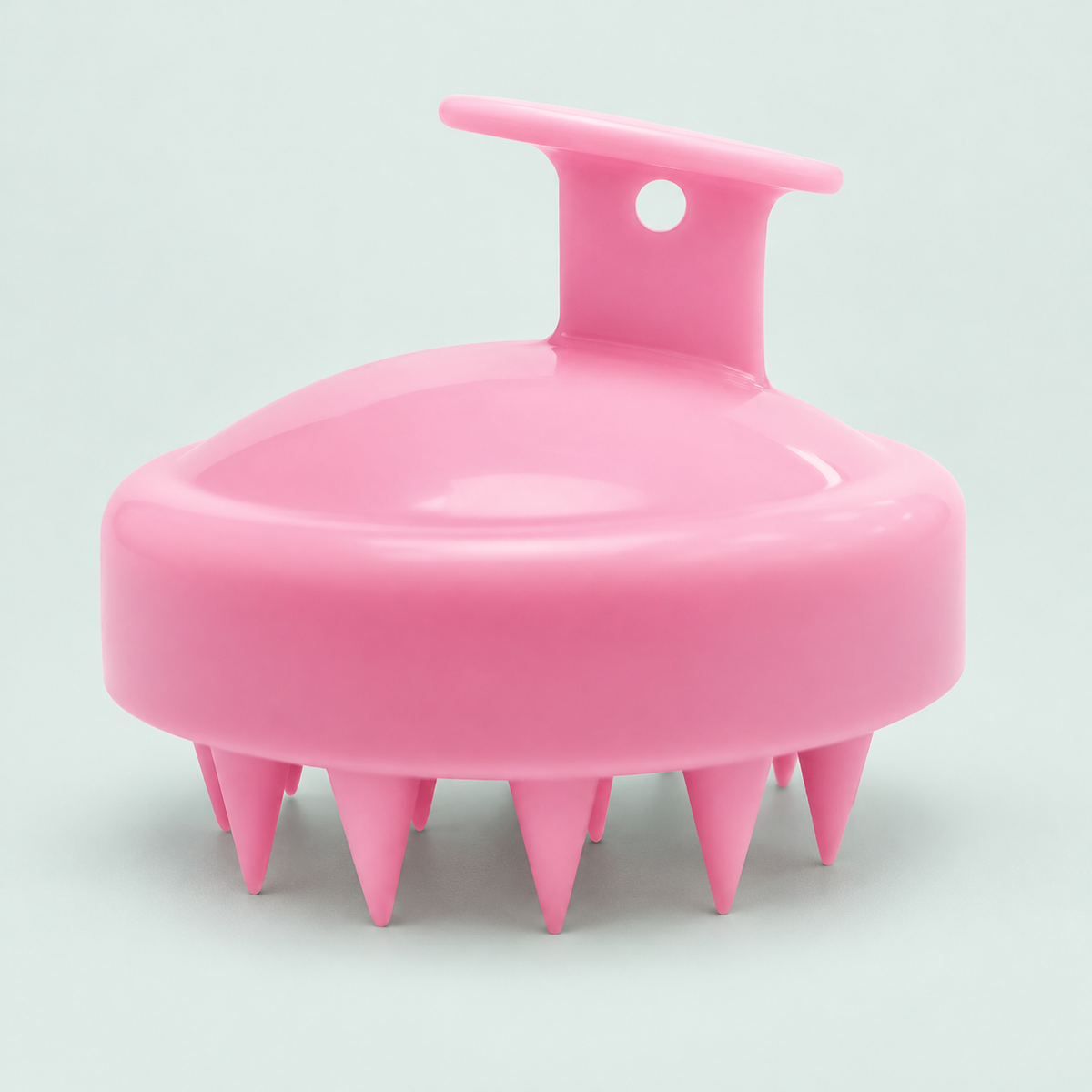 Palm scalp brush — one pink brush in a coastal studio setting.